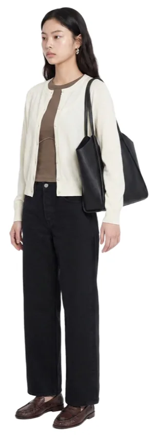 A cream cardigan over a brown top with black trousers and a black tote.